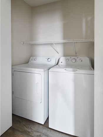 Two white front loading washing machines in a laundry room.